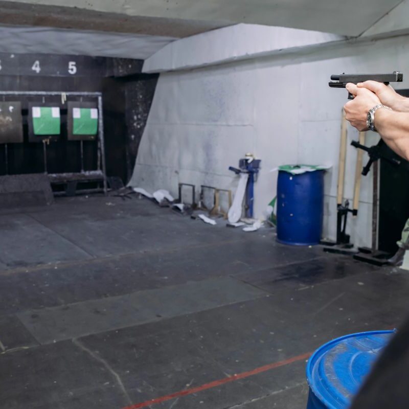 A shooter at an indoor firing lane testing if blue bullets are good for indoor shooting for better visibility and air.
