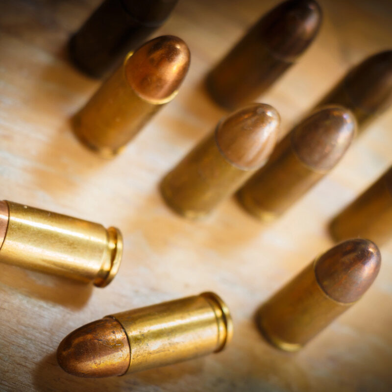 Top-down view of ACP cartridges on a wooden surface, highlighting the importance of knowing what is acp ammo for shooting.