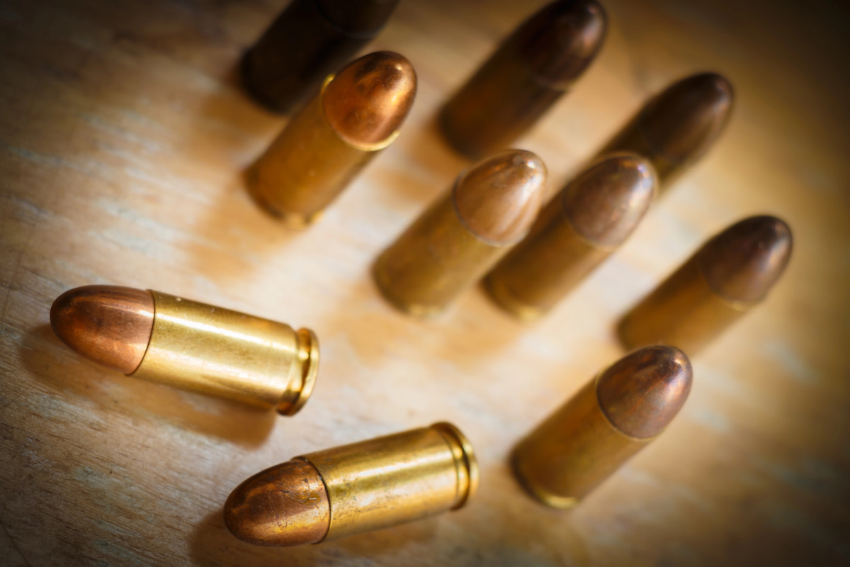 Top-down view of ACP cartridges on a wooden surface, highlighting the importance of knowing what is acp ammo for shooting.