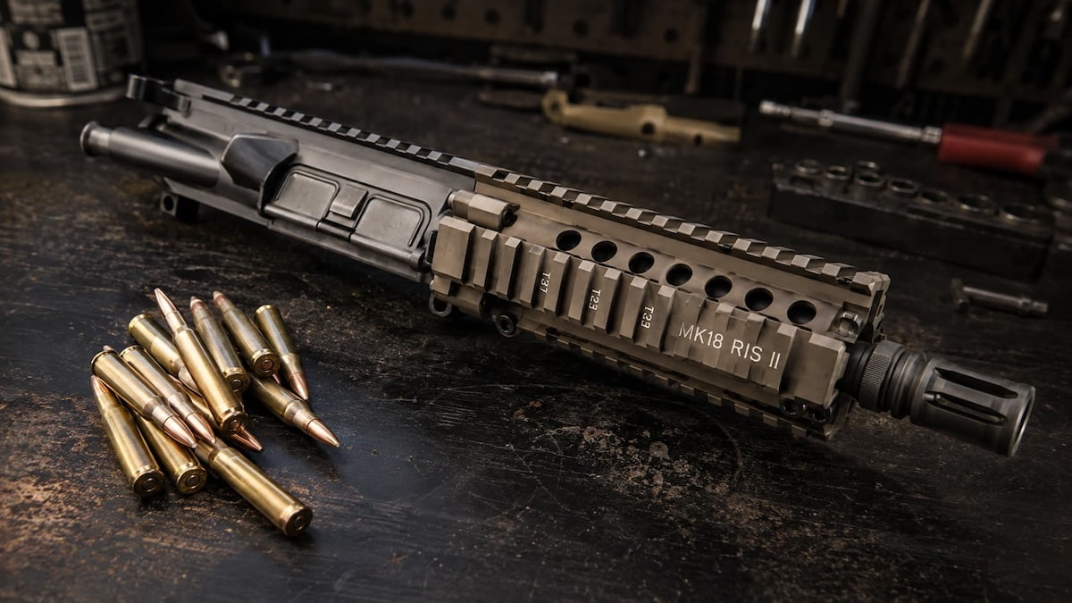MK18 SBR upper receiver on a bench next to a barrel of 5.56 cartridges showing the best ammo for MK18 short barrel setups.
