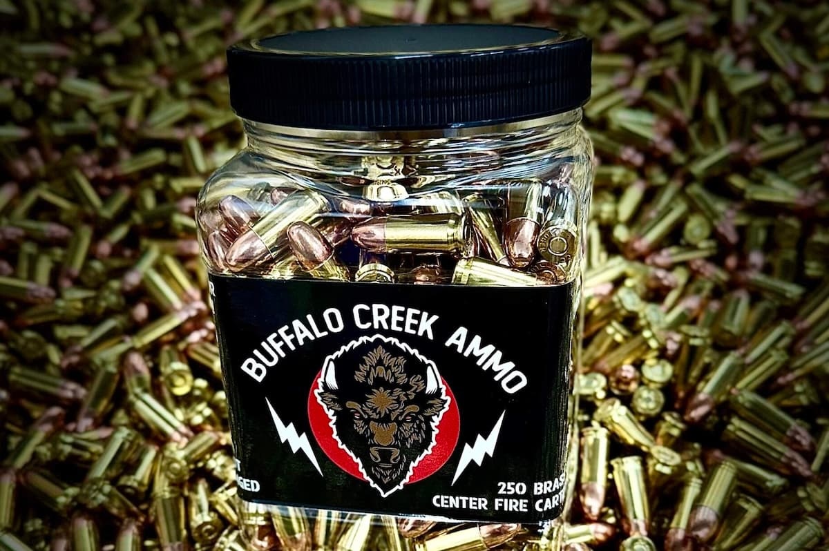 A jar of 9mm bulk ammo sitting on top of a pile of loose brass cartridges, illustrating a guide on buying bulk ammo.